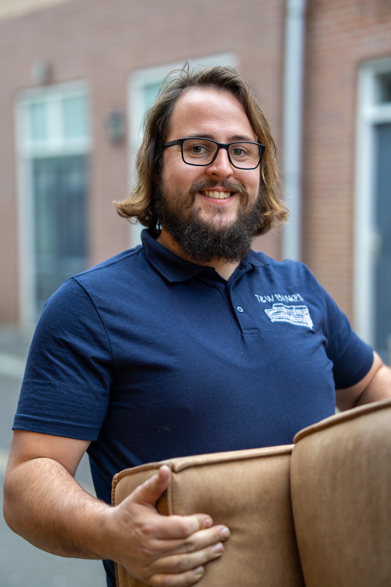 Medewerker van TW Banken tilt een bank tijdens het ophalen bij klant