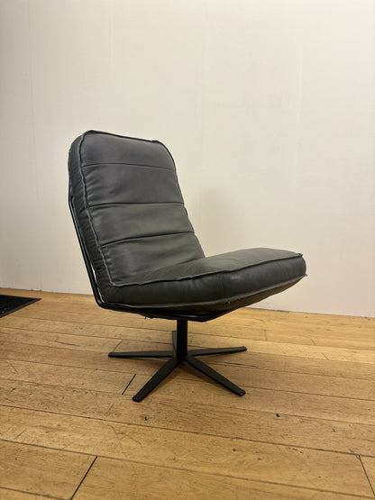 Antracietgrijze leren draaifauteuil Odin van INNO Living met comfortabele zitting en zwart metalen draaionderstel op houten vloer.