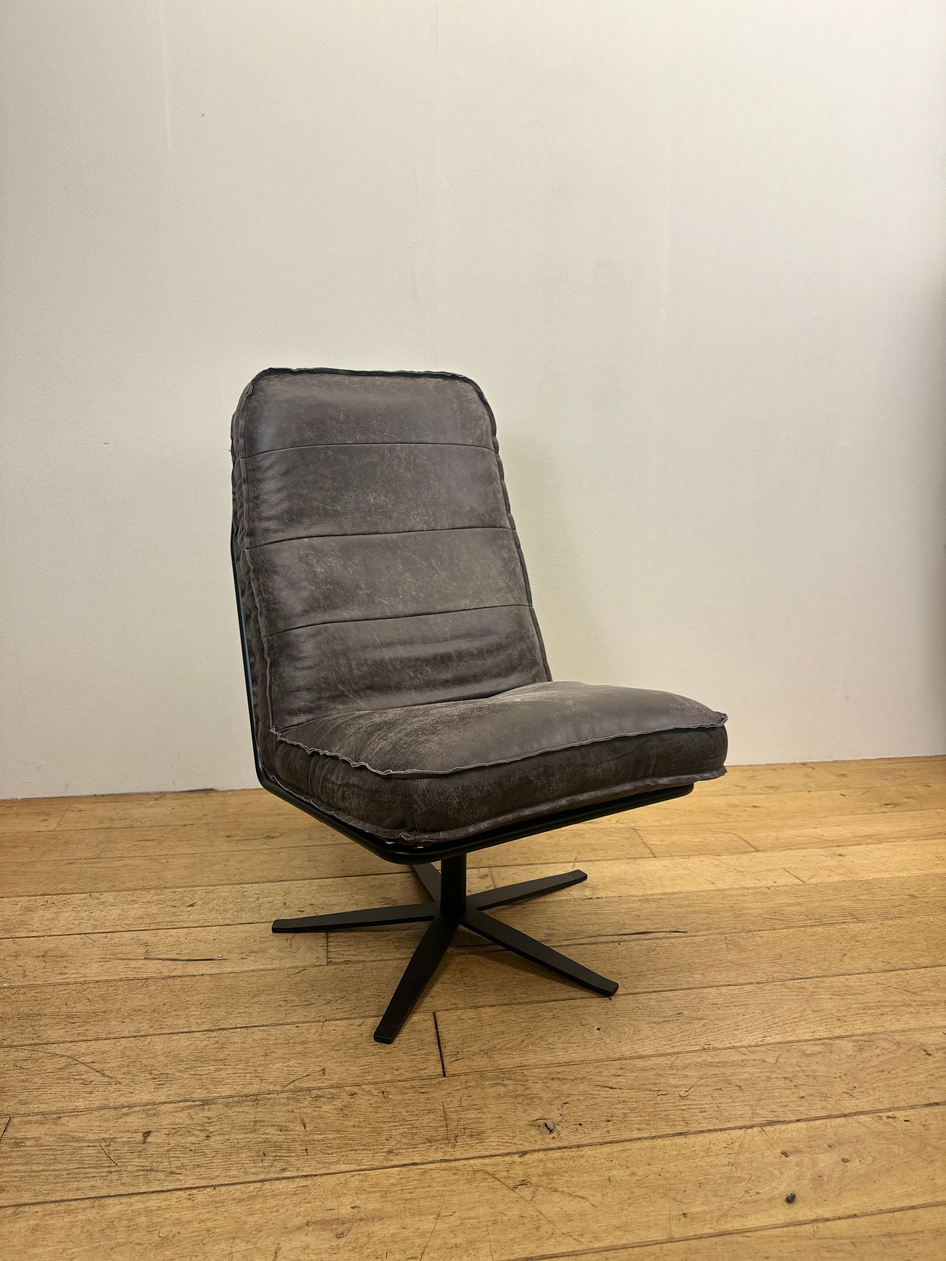 Donkerbruin leren draaifauteuil Odin van INNO Living met comfortabele zitting en zwart metalen draaionderstel op houten vloer.